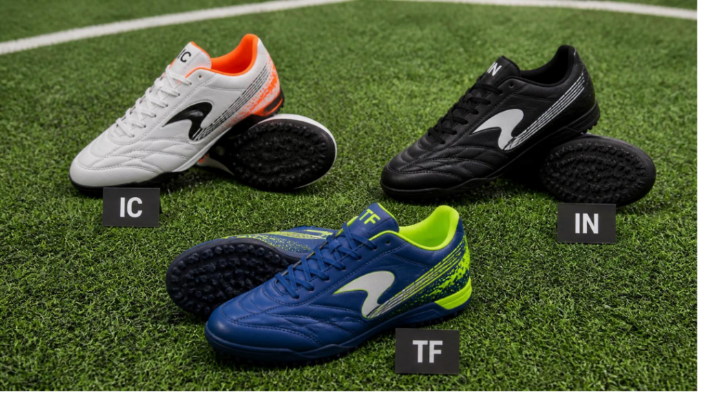 Chaussures de foot à 5 TF, IC et IN posées sur un terrain synthétique