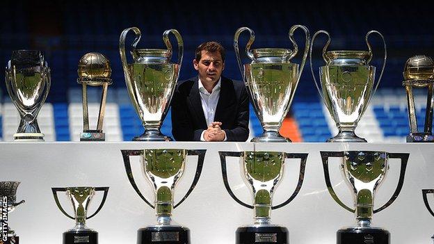 Iker Casillas pose derrière les trophées qu'il a remportés au cours de sa carrière au Real Madrid après avoir tenu une conférence de presse avec le président du Real Florentino Perez au stade Santiago Bernabeu pour annoncer qu'il quittera l'équipe de football du Real Madrid en 2015