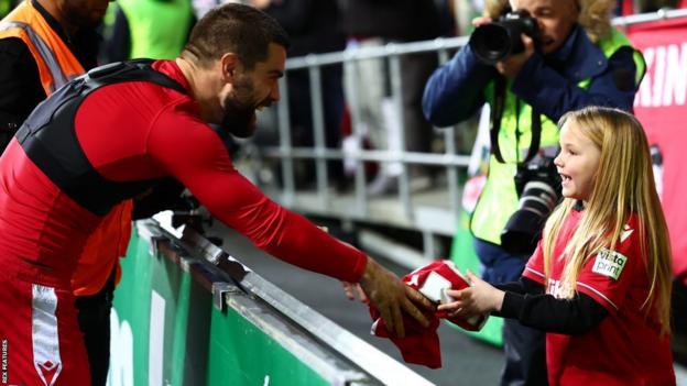 Le milieu de terrain Elliot Lee tend son maillot à un jeune fan après la victoire de Wrexham en FA Cup à Coventry le 7 janvier 2023