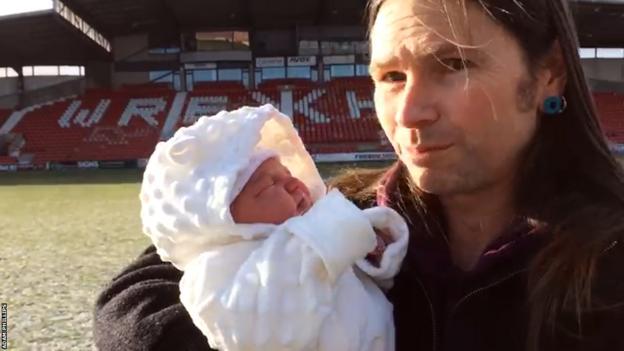 Adam Phillips avec sa fille nouveau-née Tanwen debout dans le cercle central de l'hippodrome