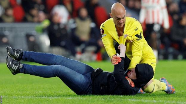 Un envahisseur de terrain affronte le gardien de Séville Marko Dmitrovic