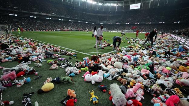 Les joueurs dégagent le terrain après que Besiktas ait jeté des ours en peluche sur le terrain pour soutenir les enfants victimes du tremblement de terre
