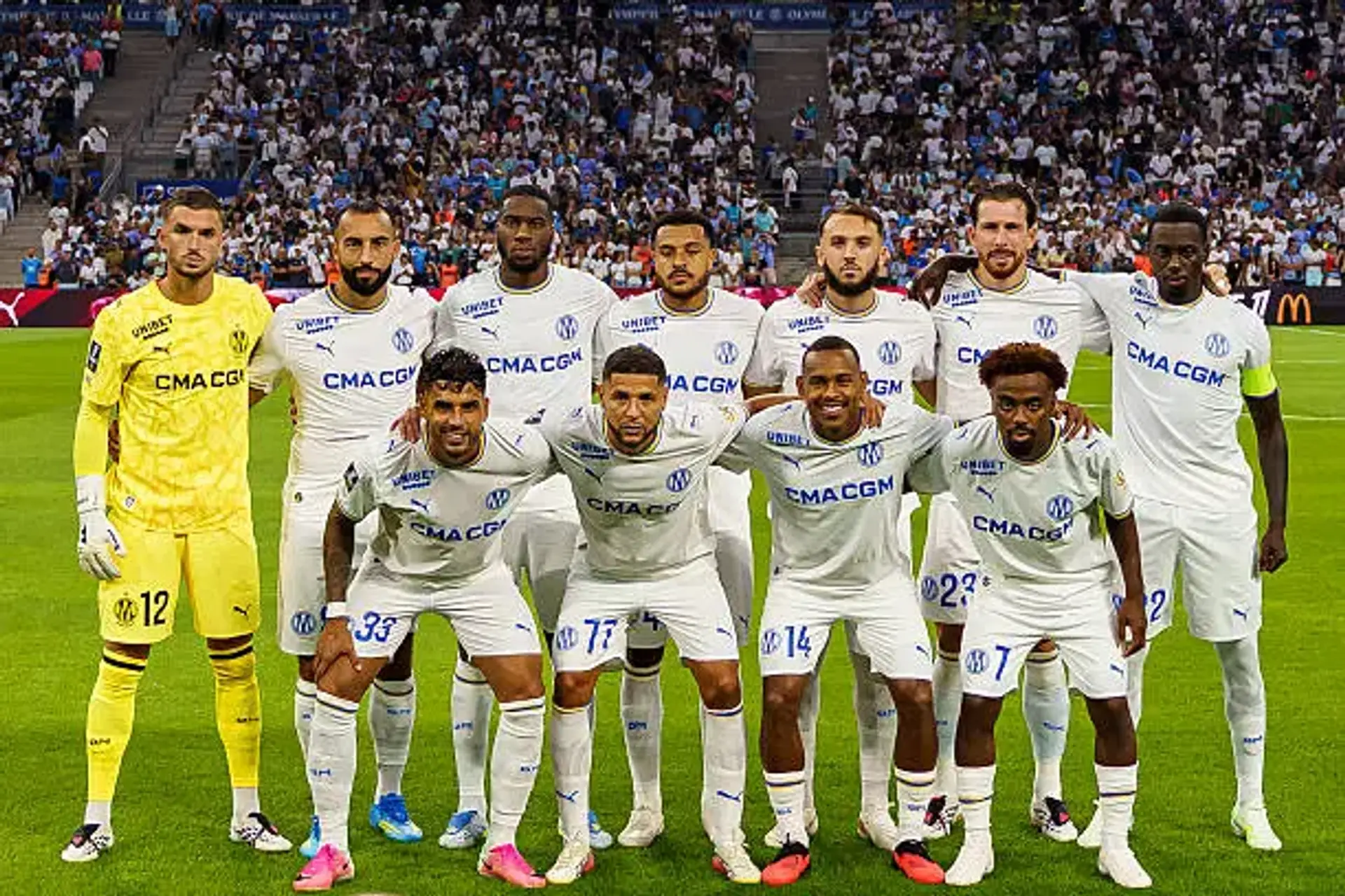 Joueurs de l'Olympique de Marseille alignés sur la pelouse avant un match de Ligue 1
